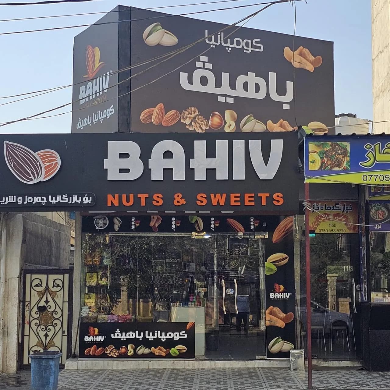 واجهة محل باهيڤ بلافتة ثنائية اللغة في دهوك
